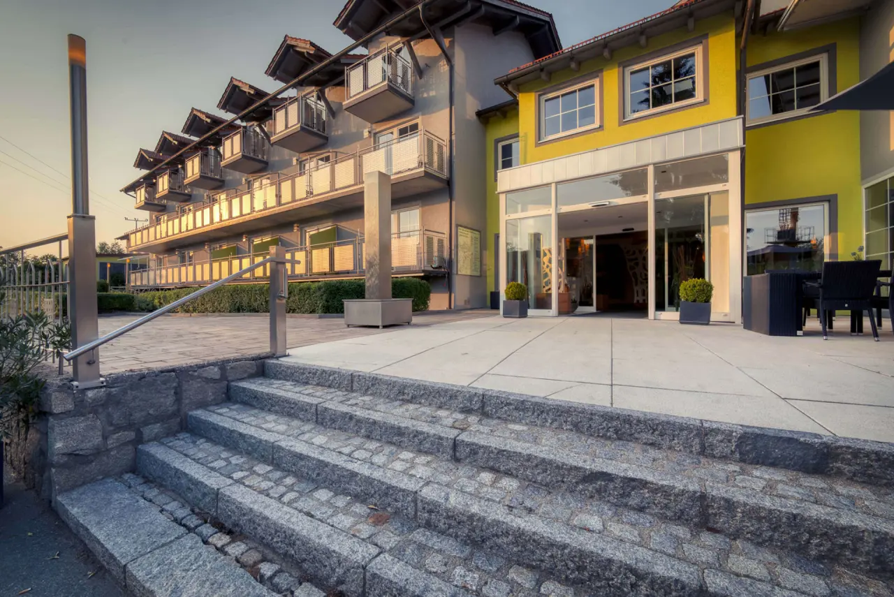 Aussenansicht des Hotel & SPA Reibener-Hof mit Eingangsbereich und Balkonen bei Sonnenuntergang.