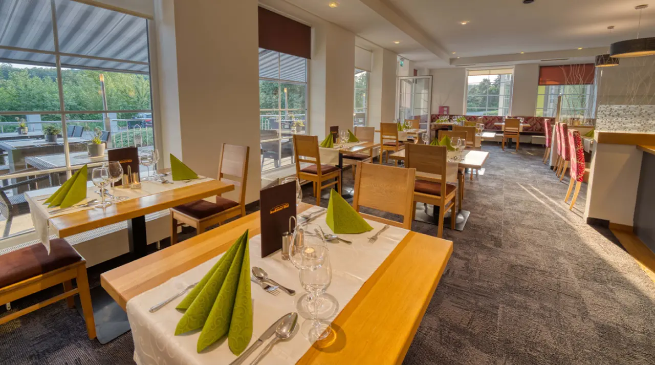 Helles Restaurant im Hotel & SPA Reibener-Hof mit gedeckten Tischen und Blick ins Grüne.