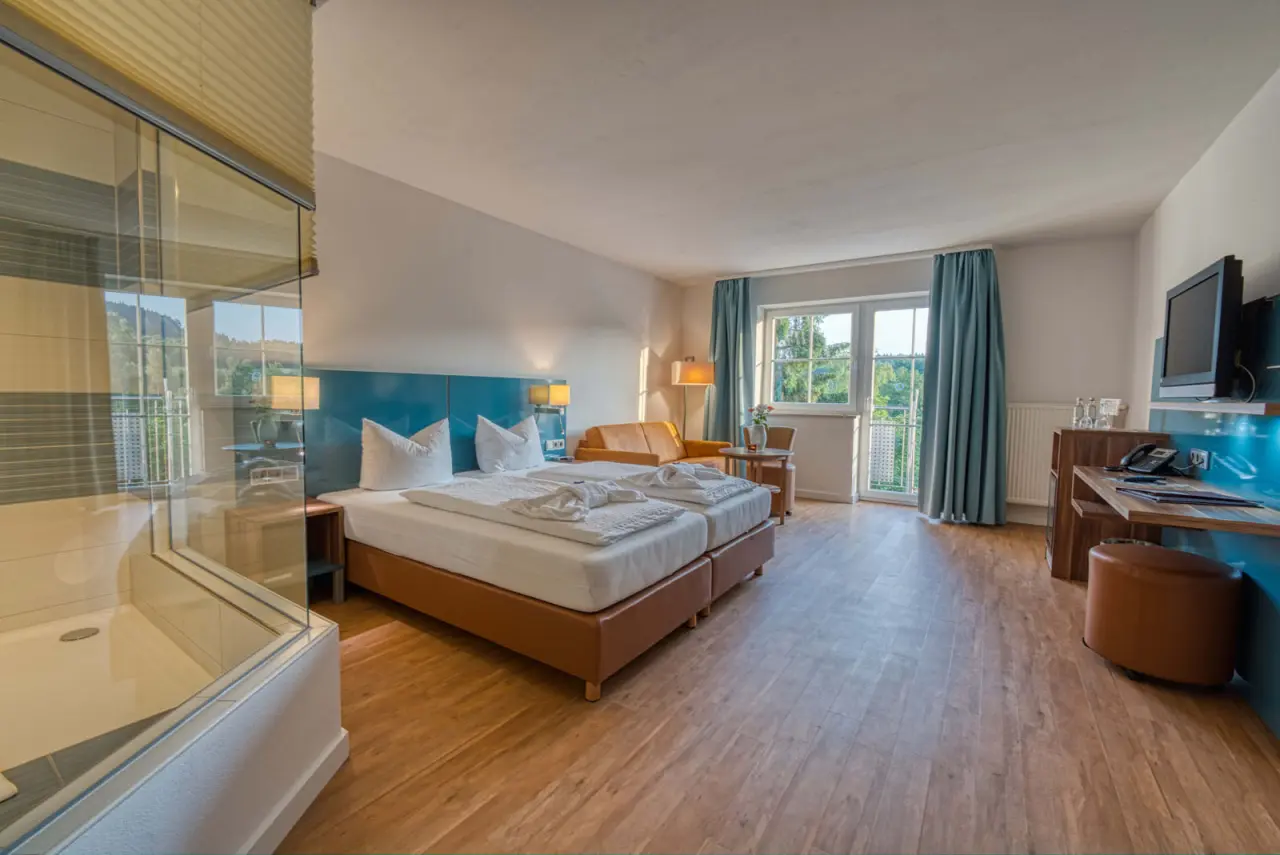 Helles Doppelzimmer im Hotel & SPA Reibener-Hof mit Holzboden, Balkon und moderner Dusche.
