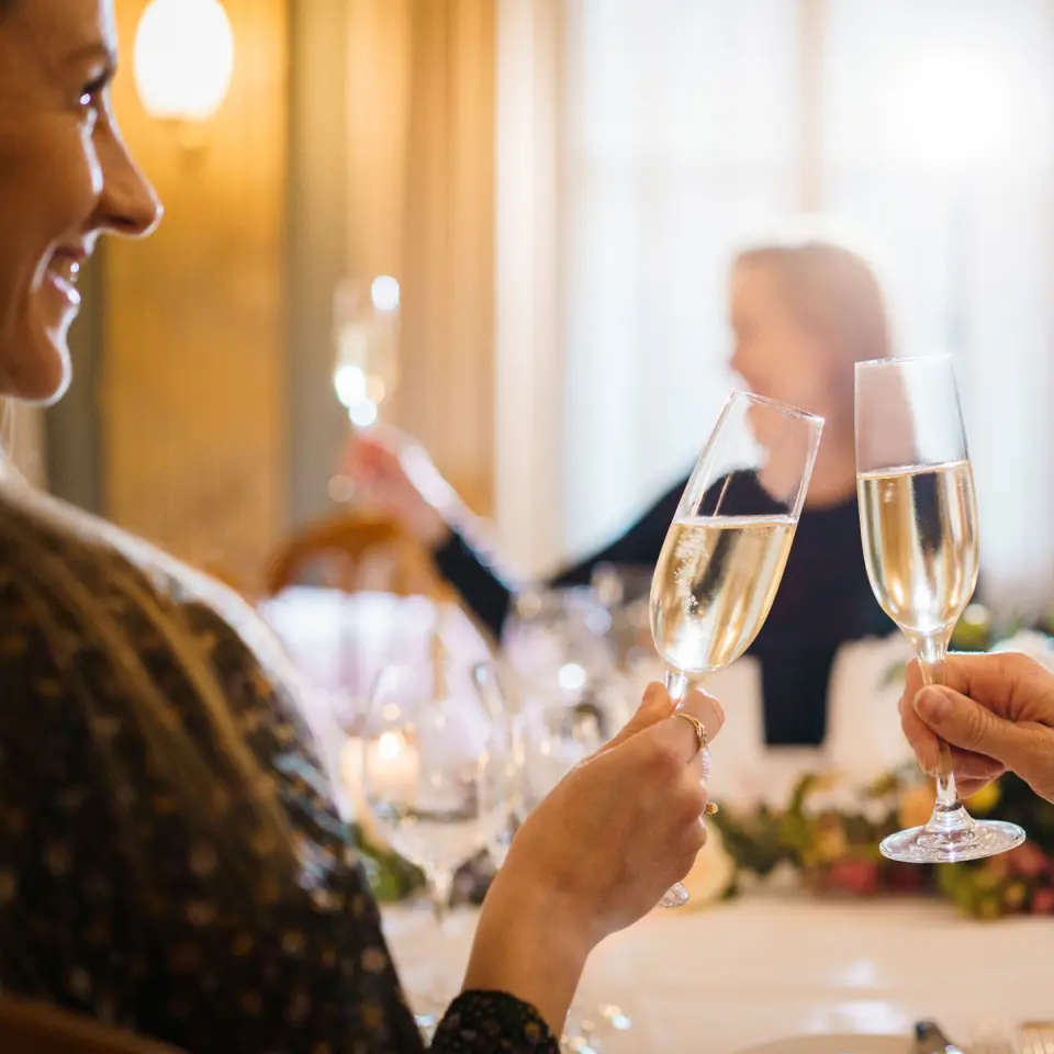 Freudiger Sekt-Anstoss von Gästen im eleganten Restaurant des BLUME. Baden Hotel & Restaurant.
