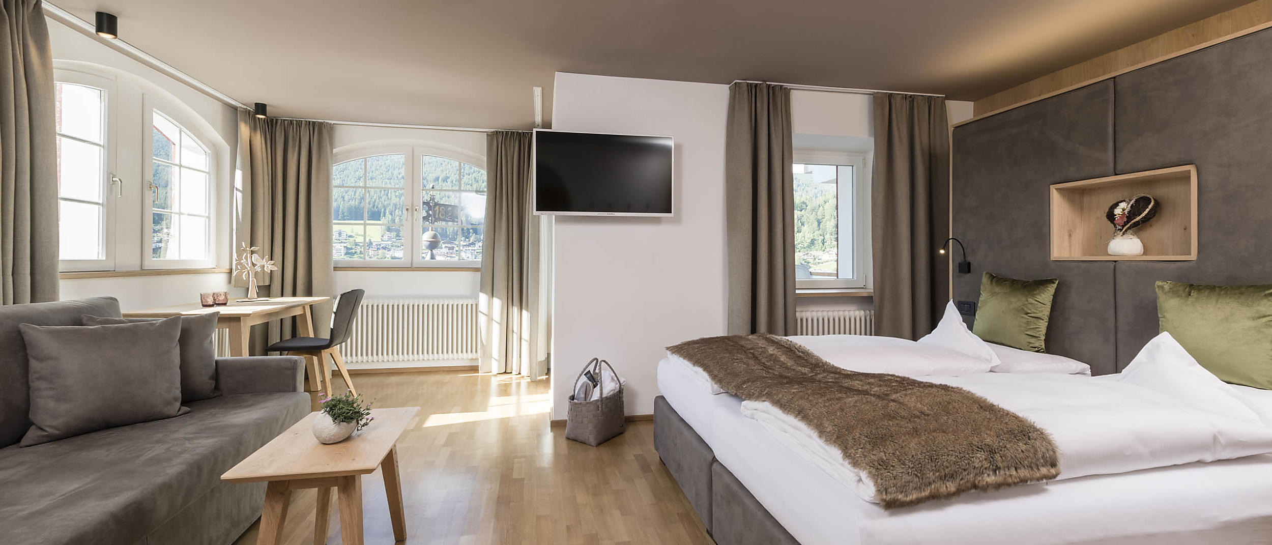 Rainell Dolomites Retreat in St. Ulrich in Gröden – Komfortables Hotelzimmer mit Bergblick und Sitzbereich | Wellnesshotel Dolomiten