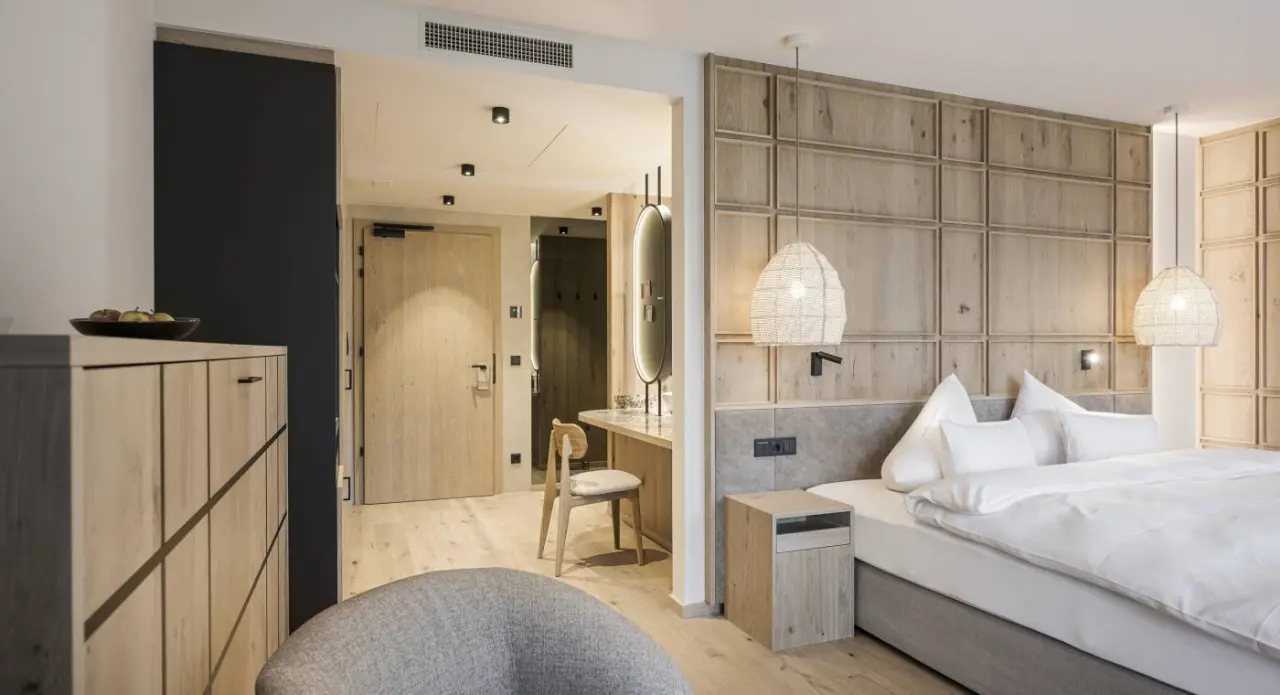 Modernes Doppelzimmer mit Holzelementen und gemütlichem Bett im Alpenresort Schwarz.