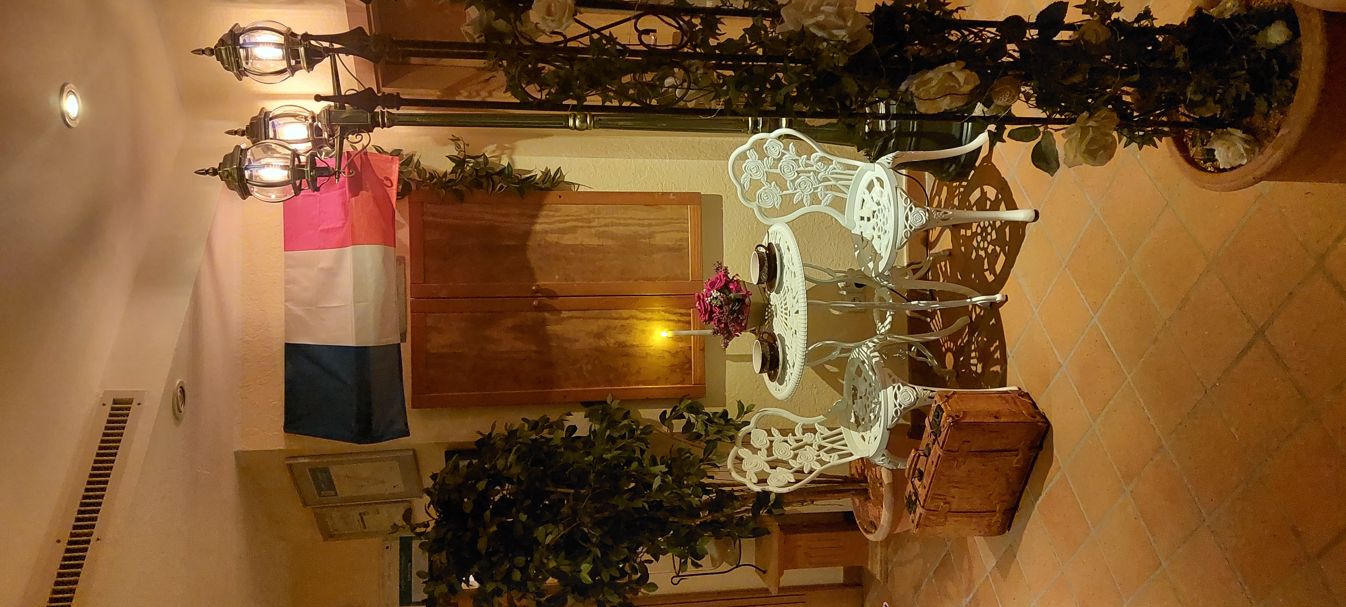 Landhotel Grimmeblick in Winterberg – Dekorative Sitzgruppe mit Laterne und Blumen in einem Innenbereich | Wellnesshotel Sauerland