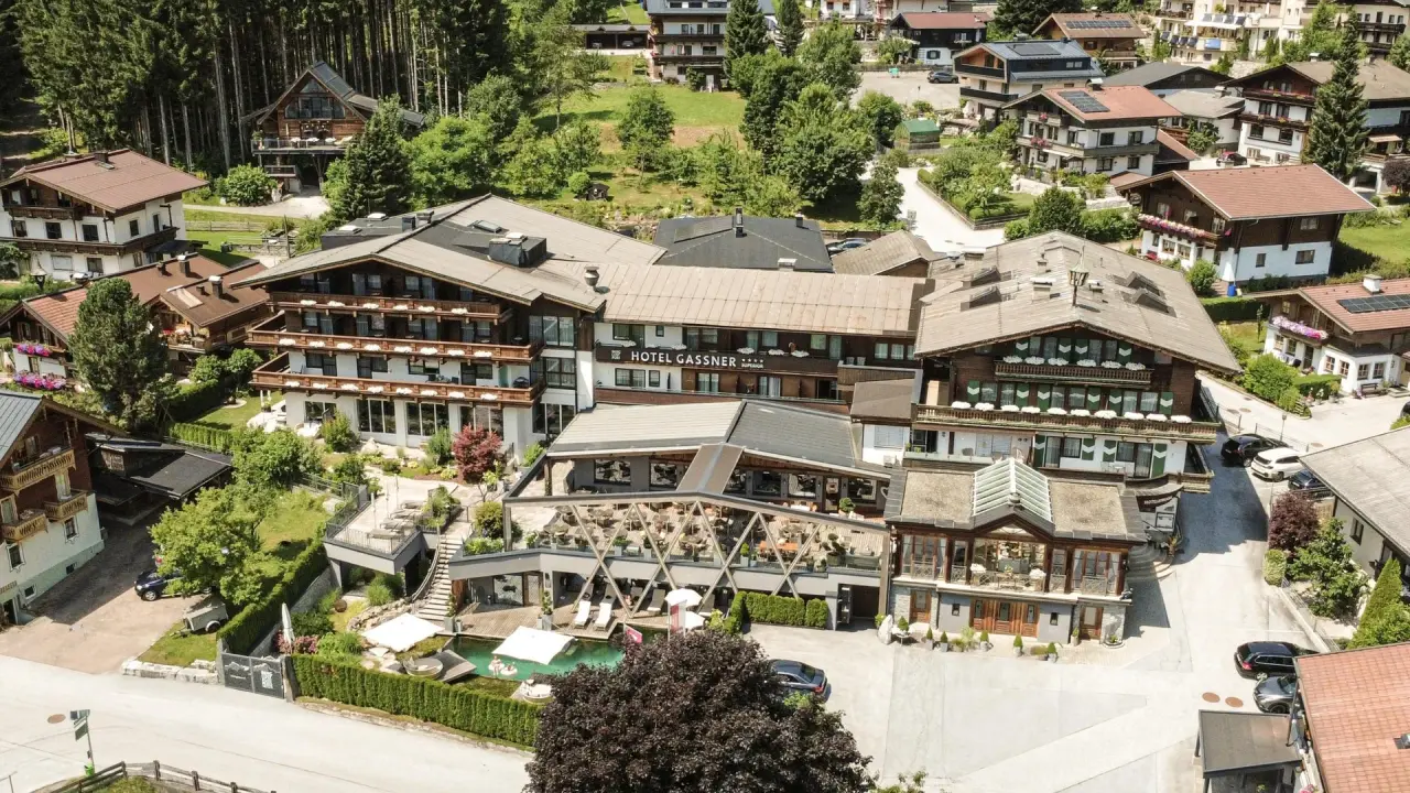 Luftaufnahme des Hotel Gassner 4 Sterne Superior mit Pool und umliegender Natur in den österreichischen Alpen.