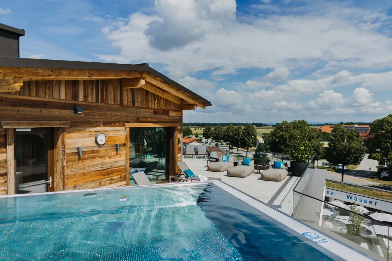 Dachterrassen-Infinity-Pool mit Holzarchitektur und weitem Blick über die Landschaft im Ortner's Resort.