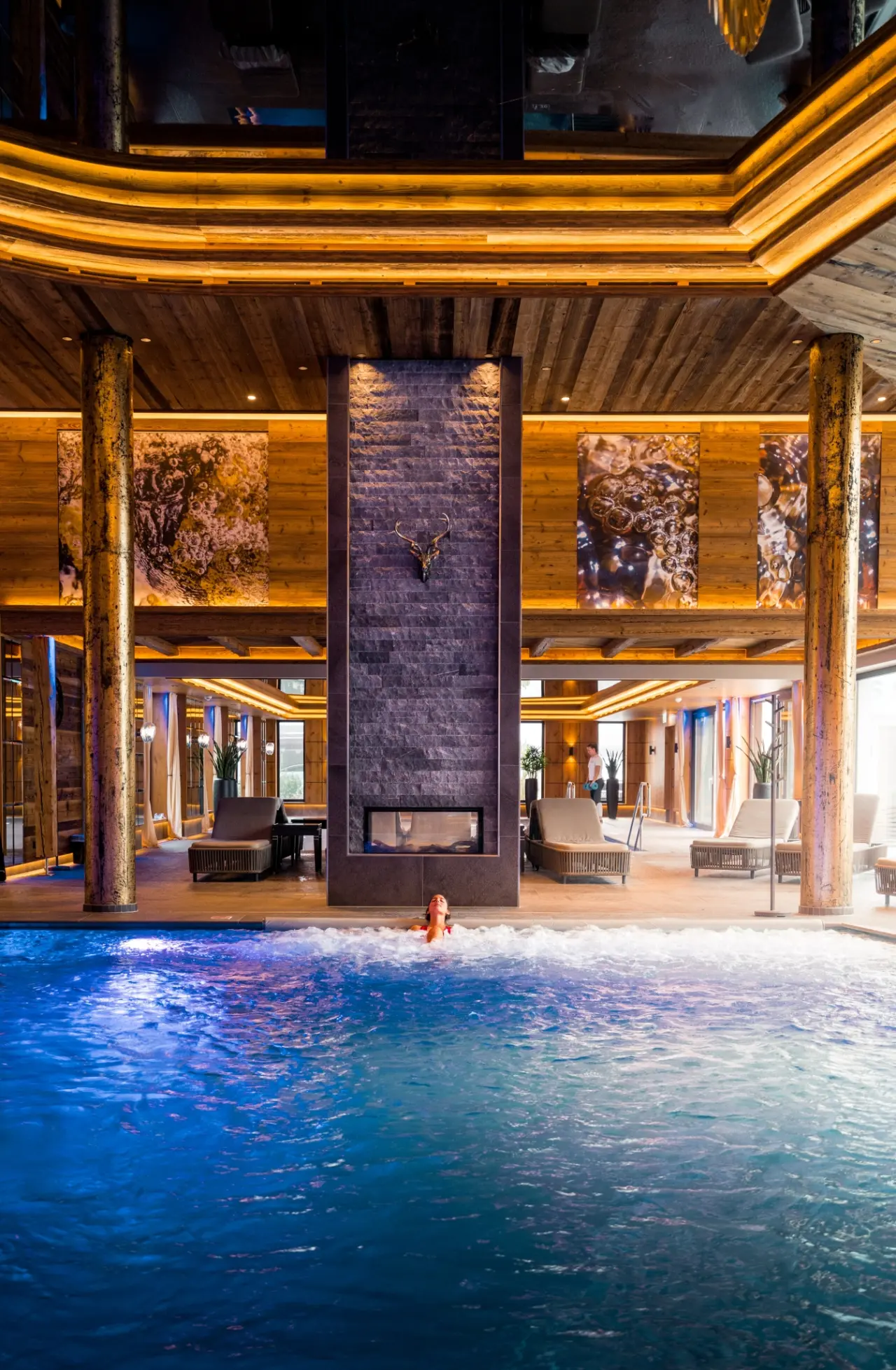 Luxuriöser Innenpool mit Whirlpool, Kamin und Holzdesign im Wellnessbereich des Ortner's Resort.