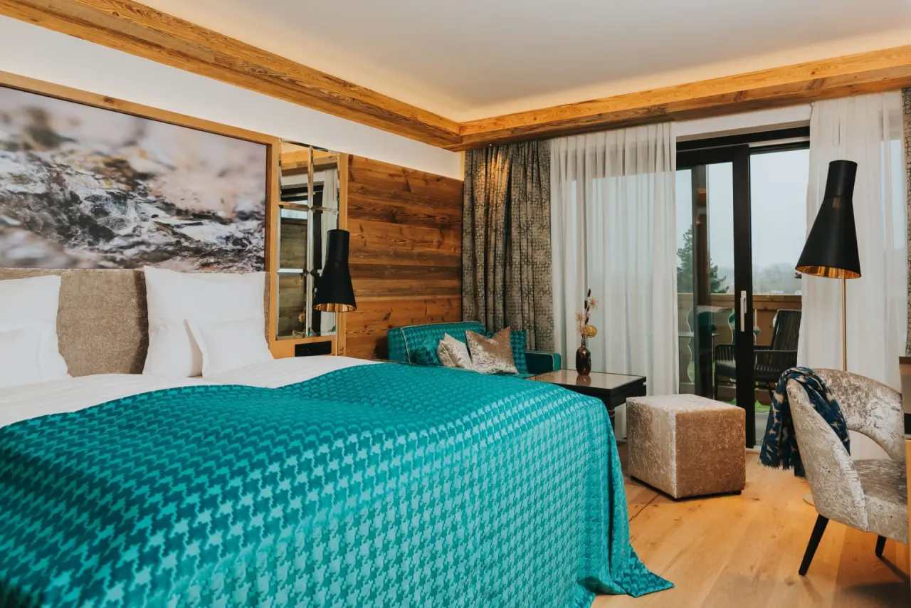 Gemütliches Doppelzimmer im alpinen Stil mit Balkon und Blick ins Grüne im Ortner's Resort.