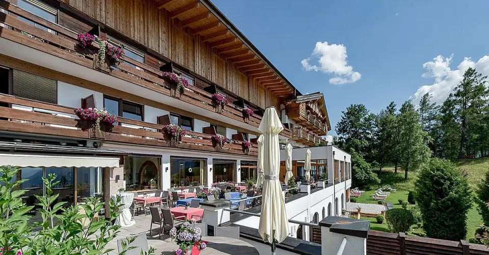 Aussenansicht des Inntalerhof - DAS Panoramahotel mit blühenden Balkonen, Sonnenterrasse und Liegewiese im Grünen.