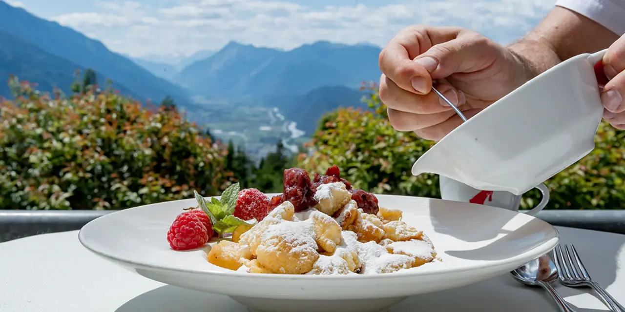 Kaiserschmarrn mit Beeren auf der Sonnenterrasse des Inntalerhof mit atemberaubendem Bergblick auf das Inntal.