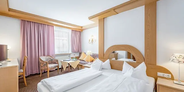 Traditionelles Doppelzimmer mit Holzelementen und Sitzbereich im Inntalerhof - DAS Panoramahotel.