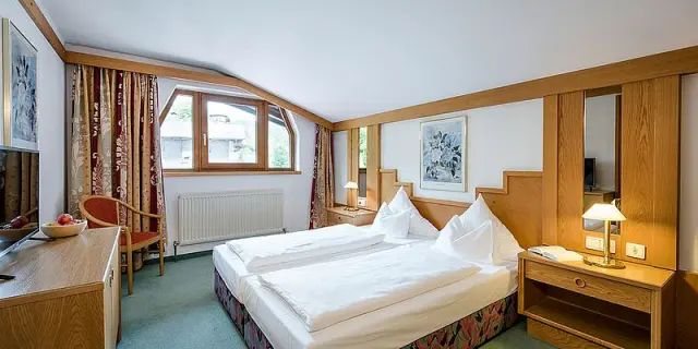 Gemütliches Doppelzimmer im Inntalerhof - DAS Panoramahotel mit Holzelementen, bequemen Betten und Fenster.