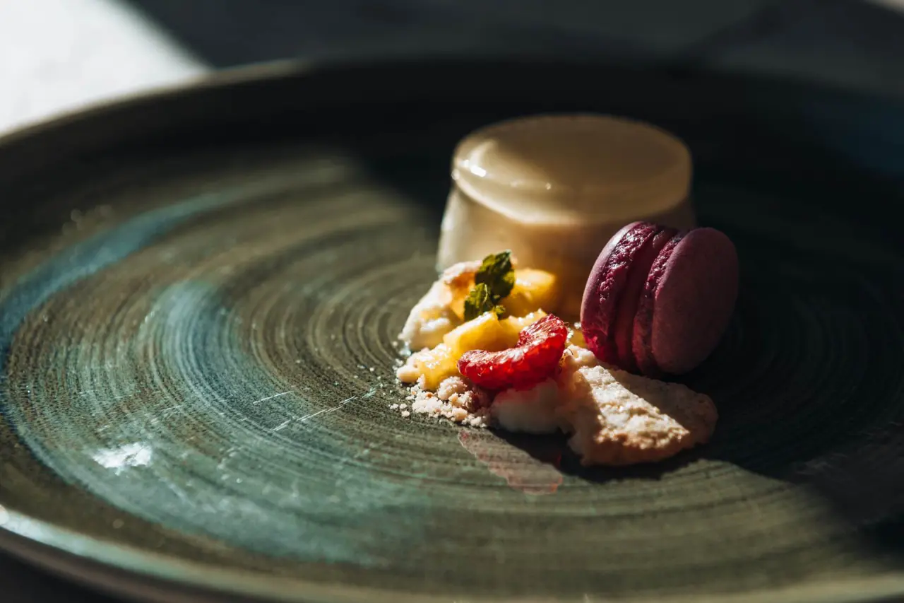 Exquisites Dessert mit Panna Cotta, Himbeeren und Macaron im Restaurant des Hotel Alpina Deluxe.