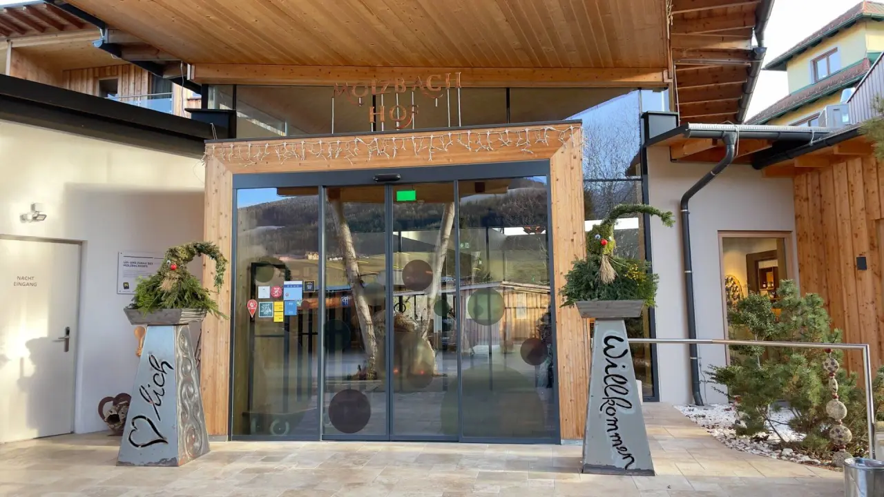 Moderner Eingangsbereich des Wellnesshotels Molzbachhof mit Holzelementen und Willkommensdekoration.
