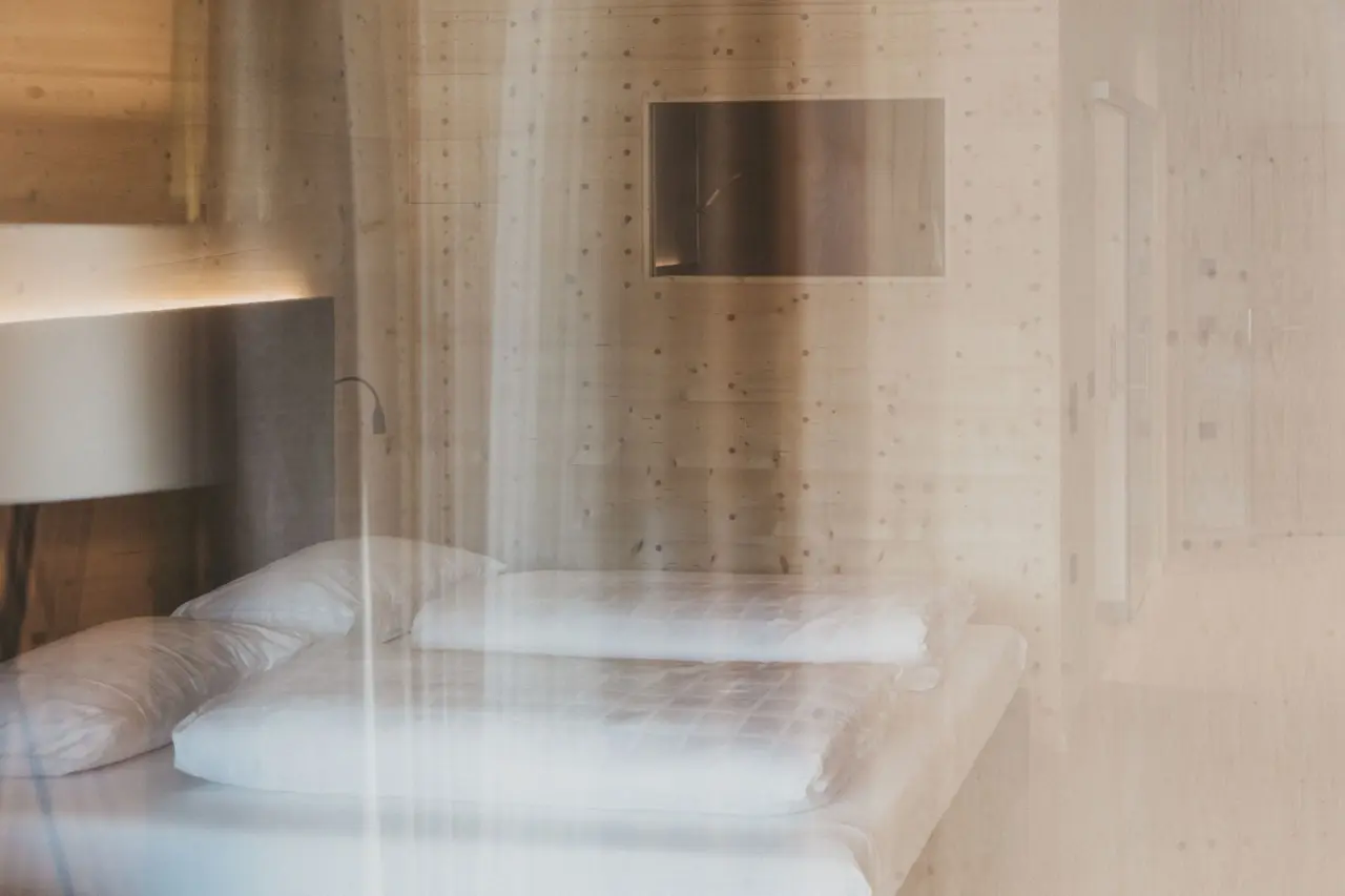 Modernes Doppelzimmer mit Holzwänden, bequemen Betten und indirekter Beleuchtung im Hotel Molzbachhof.