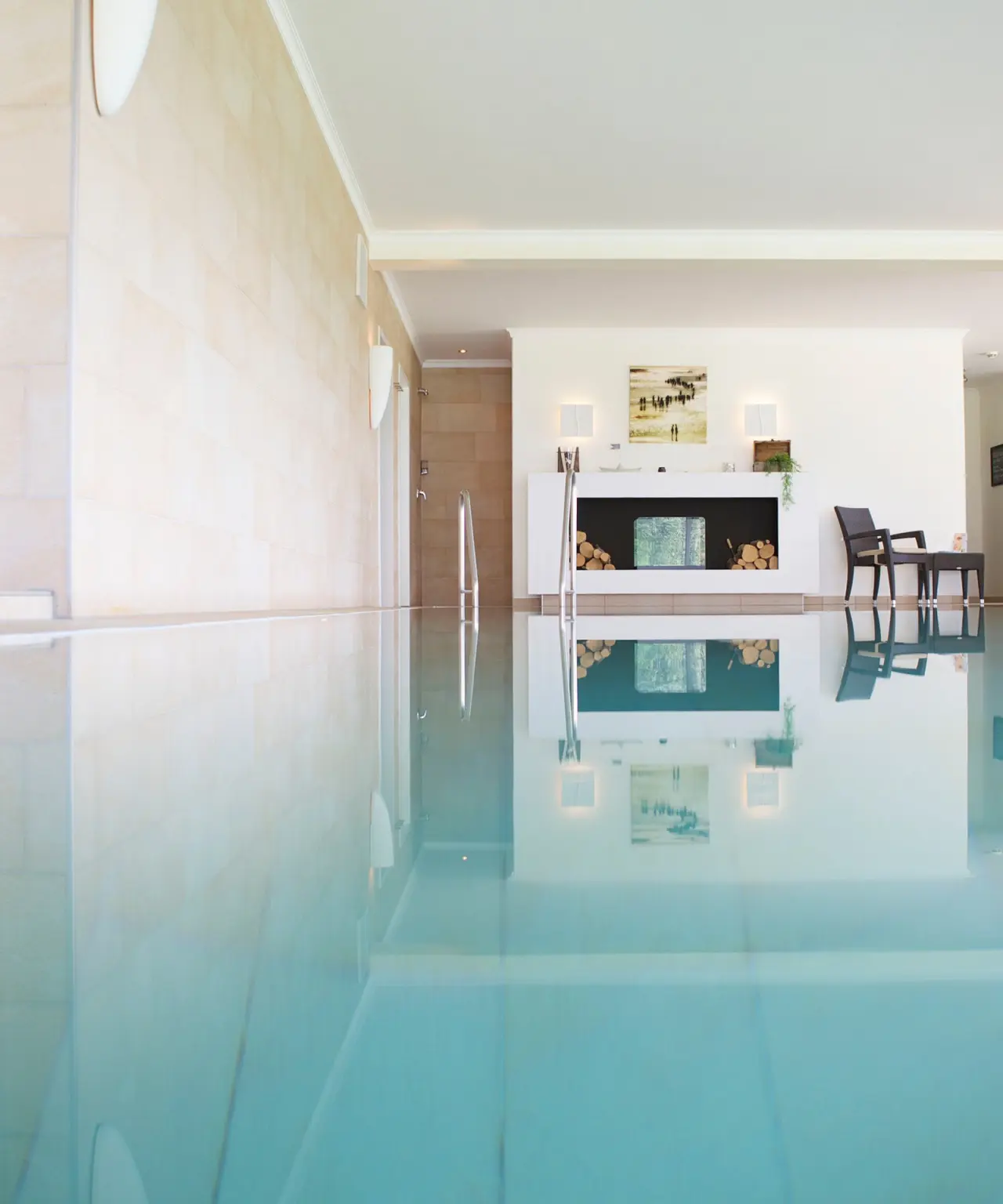 Modernes Hallenbad mit stilvoller Dekoration und bequemen Sitzgelegenheiten im Lundenbergsand Nordsee Hideaway und Spa.