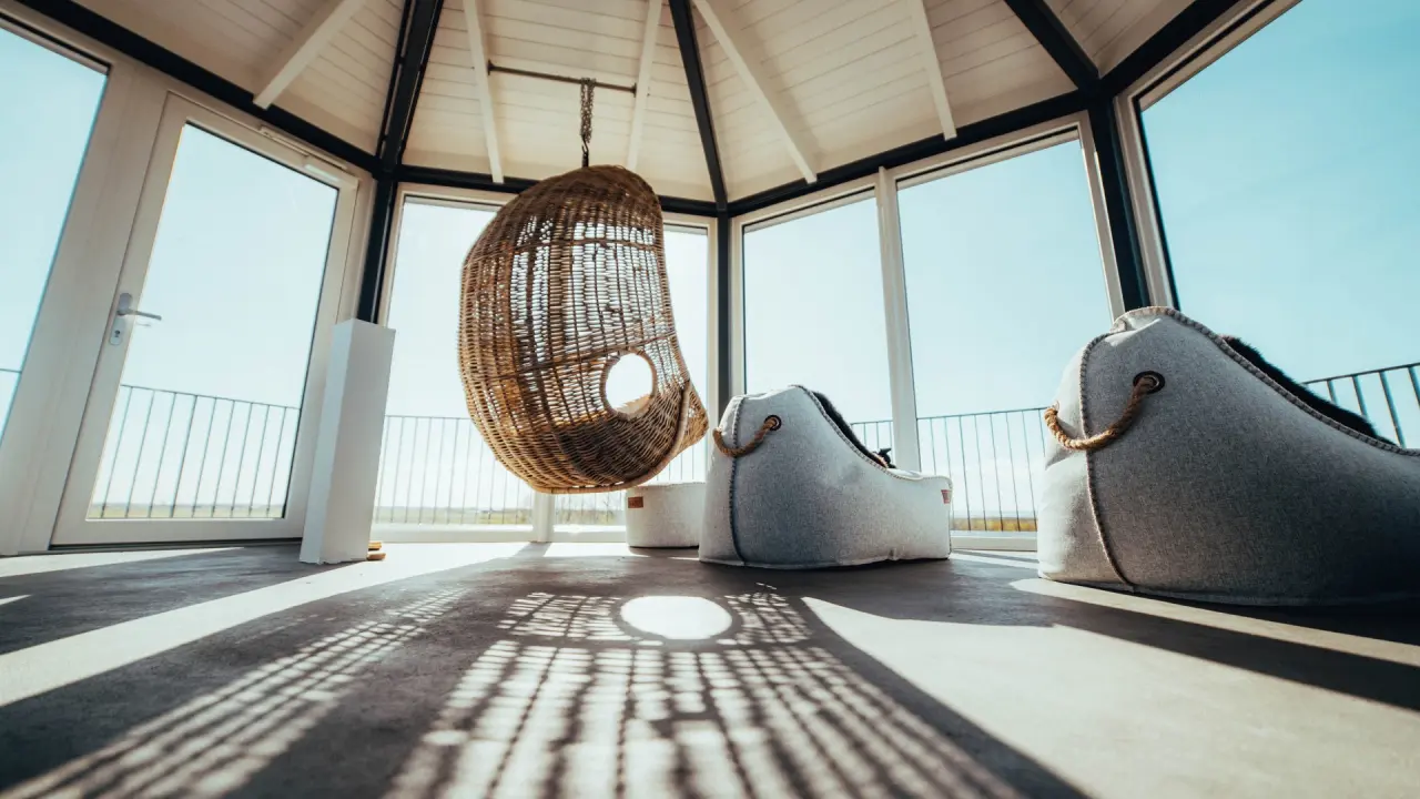 Gemütlicher Ruheraum mit Hängesessel und Panoramablick im Lundenbergsand Nordsee Hideaway und Spa.