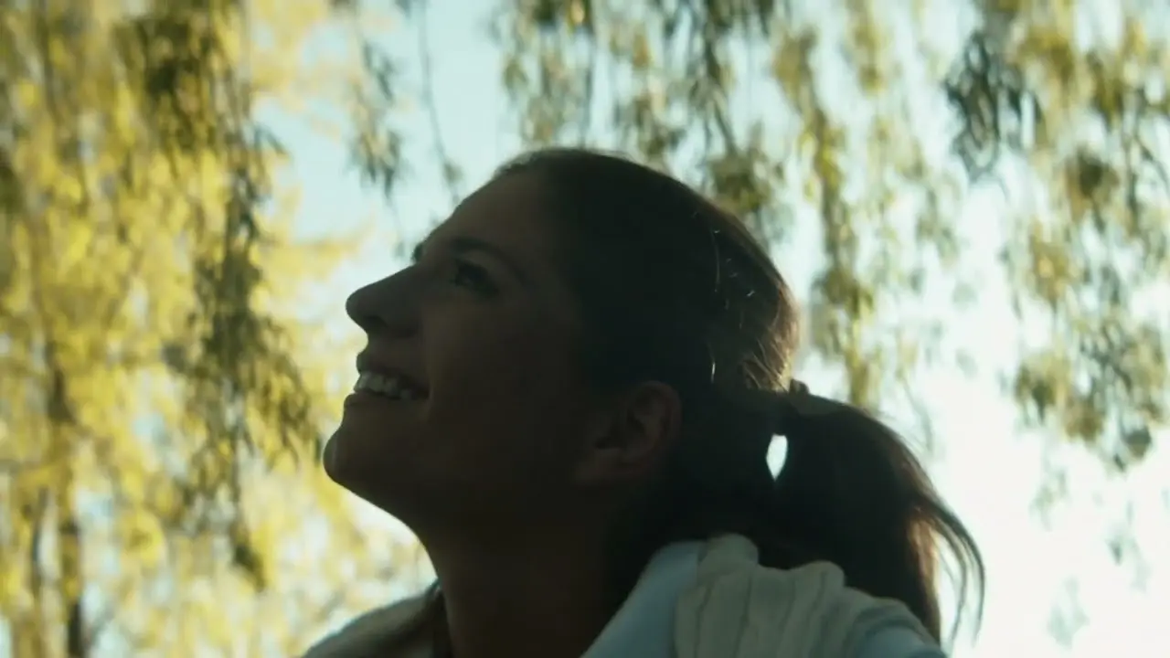 Lächelnde Frau genießt die Natur unter Bäumen im Freien, Hotel Guglwald.