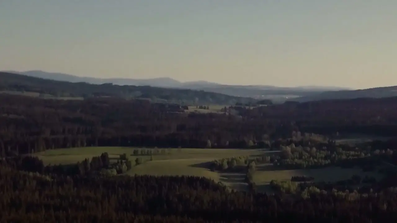 Panoramablick auf die bewaldete Hügellandschaft rund um das Hotel Guglwald bei Sonnenuntergang.