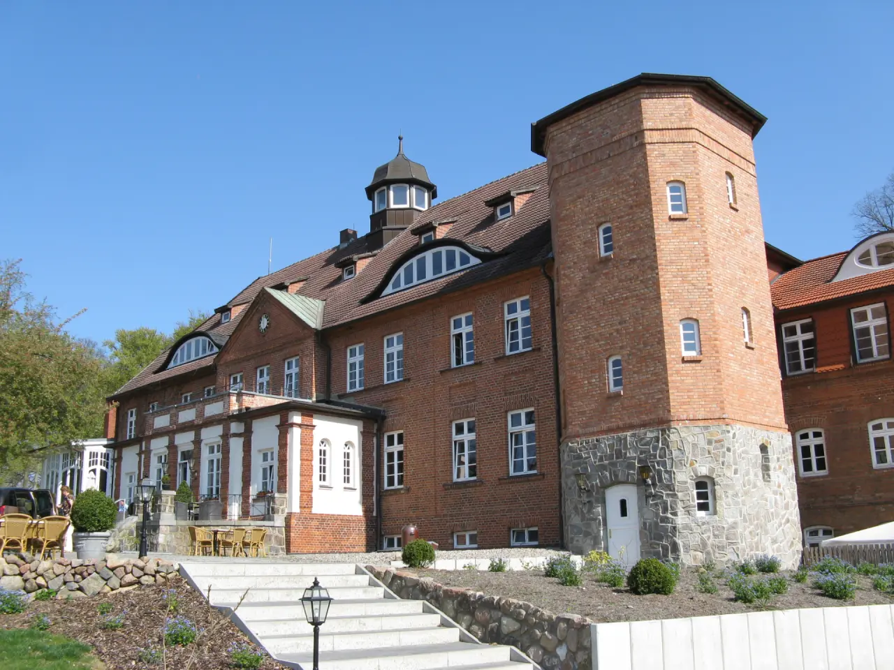 Majestätische Aussenansicht des Schlosses Basthorst an einem sonnigen Tag mit Terrasse und gepflegtem Gartenbereich.