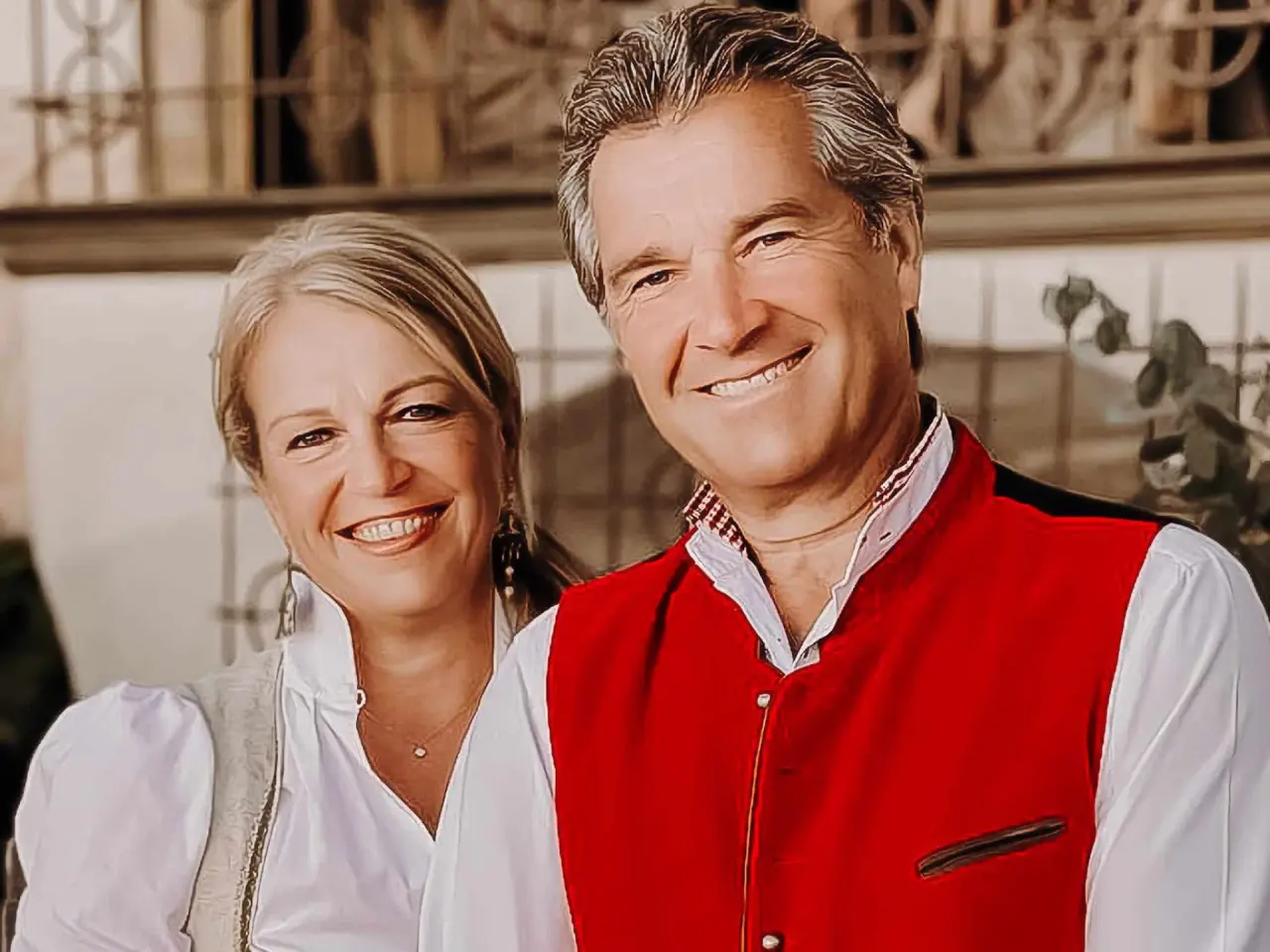 Lachendes Gastgeberpaar des Boutiquehotel Haidachhof in traditioneller Kleidung.