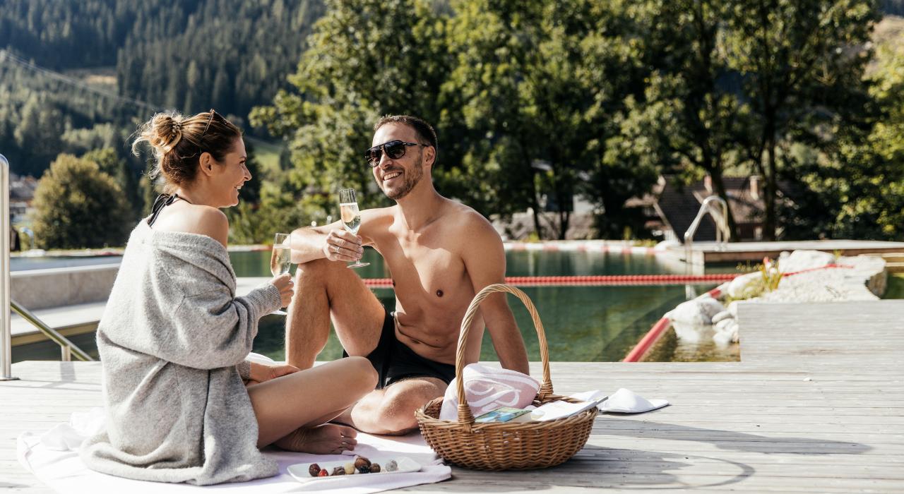 Hotel Pulverer in Bad Kleinkirchheim – Paar genießt Picknick am Pooldeck im Grünen | Wellnesshotel Kärnten