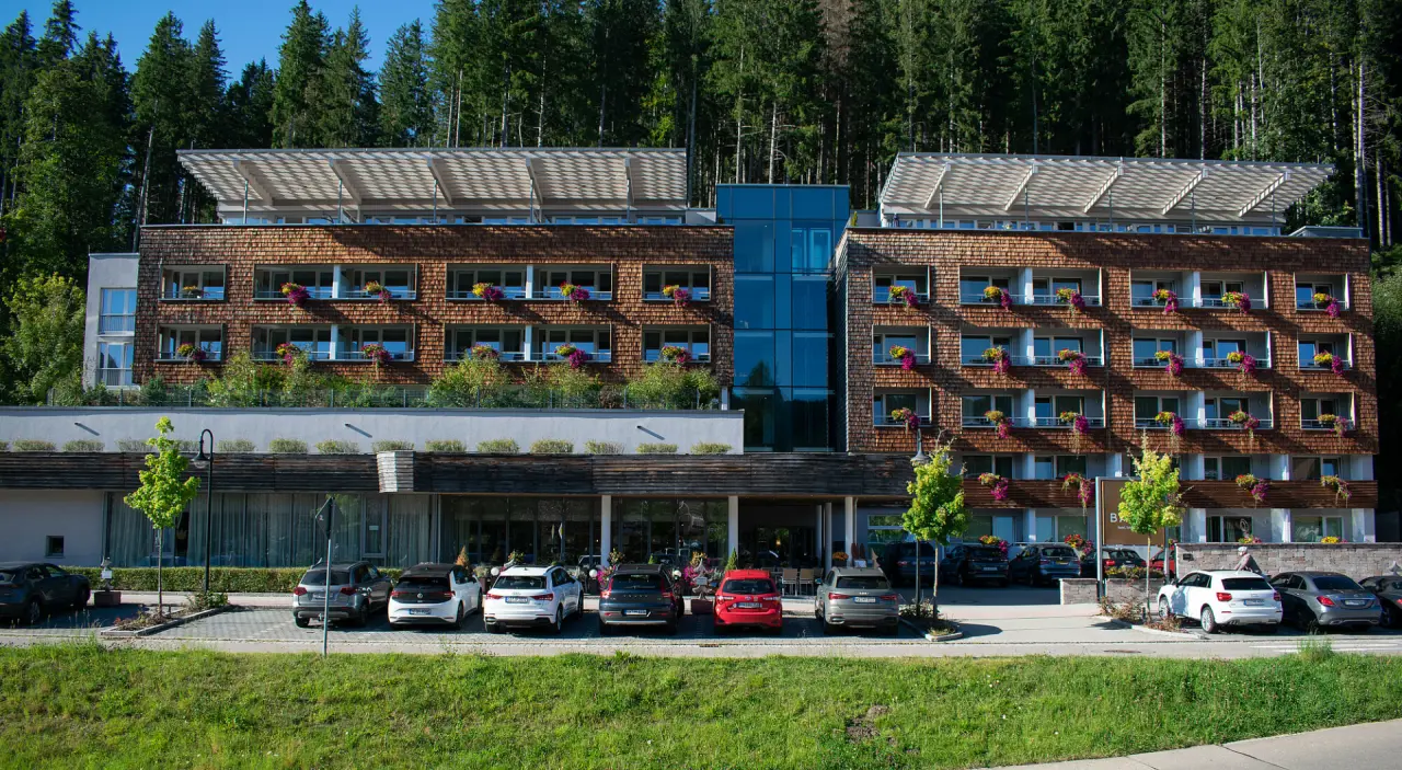 Moderne Aussenansicht des Hotel Bären Titisee mit Holzfassade, Balkonen und Blumen, eingebettet in den Schwarzwald.