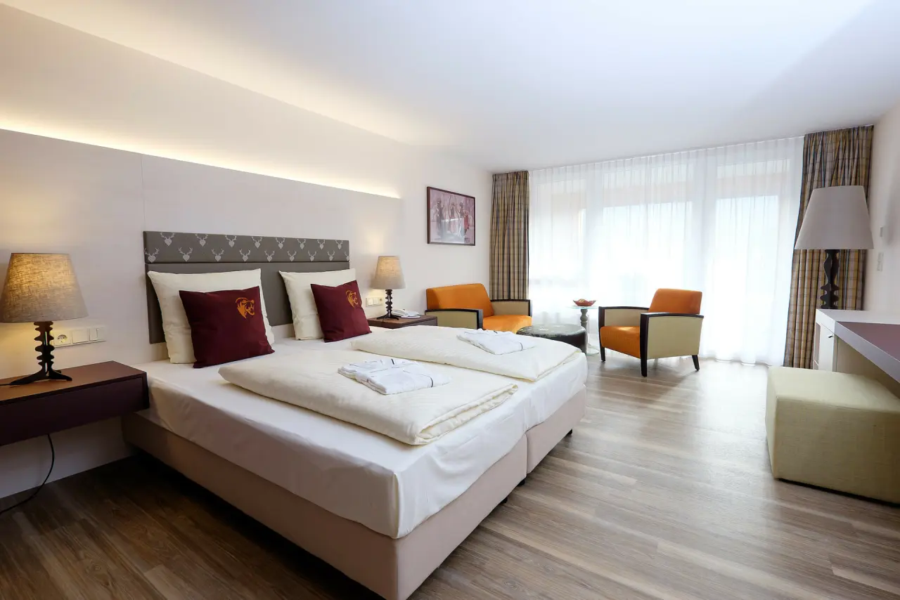 Modernes Doppelzimmer mit bequemen Betten, Sitzbereich und Holzboden im Hotel Bären Titisee