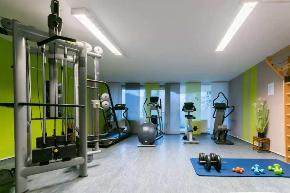 Fitnessbereich im Hotel Panoramic mit modernen Kraft- und Cardiogeräten sowie Hanteln und Gymnastikmatte.