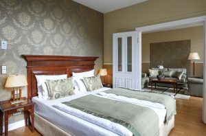 Geräumiges Hotelzimmer mit Doppelbett und separatem Wohnbereich im ATLANTIC Grand Hotel Travemünde.