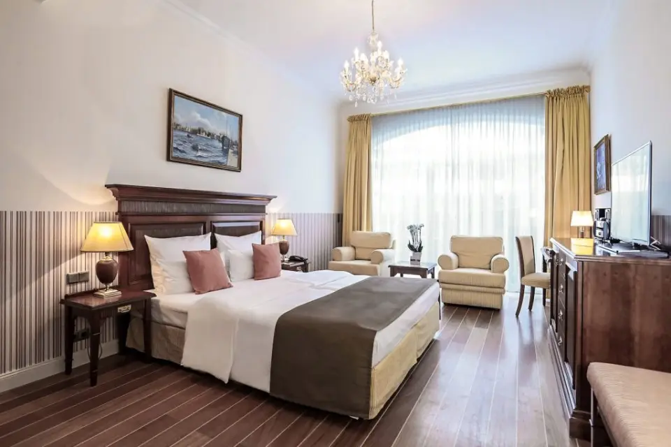 Komfortables Doppelzimmer mit elegantem Holzboden und Kronleuchter im ATLANTIC Grand Hotel Travemünde.