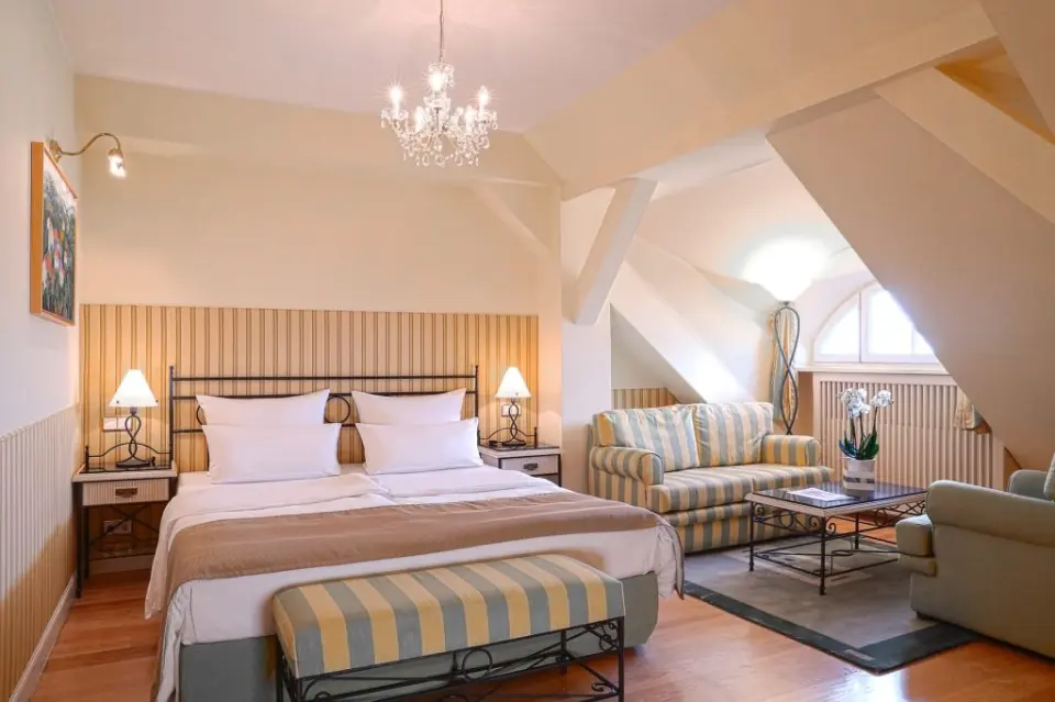Gemütliches Doppelzimmer mit Dachschräge und Sitzbereich im ATLANTIC Grand Hotel Travemünde.