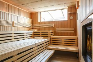 Moderne finnische Sauna mit Holzvertäfelung und Tageslicht im ATLANTIC Grand Hotel Travemünde Spa-Bereich.