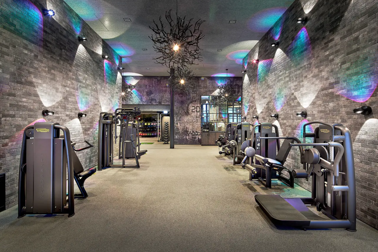 Modernes Fitnessstudio mit Technogym Geräten und farbiger Beleuchtung im 5-Sterne Wellness- & Sporthotel Jagdhof.
