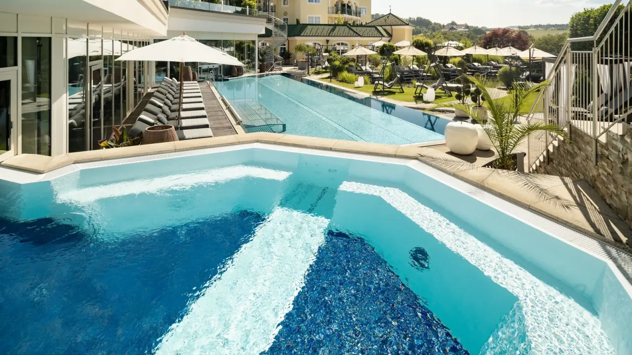 Luxuriöser Aussenpoolbereich mit Infinity-Pool und Sonnenterrasse im 5-Sterne Wellness- & Sporthotel Jagdhof.