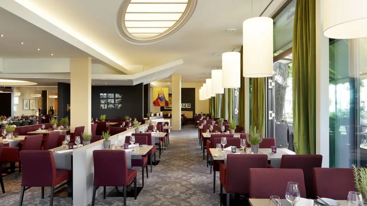 Modernes Restaurant im Best Western Premier Park Hotel & Spa mit eleganten Tischen, bequemen Stühlen und Blick ins Grüne.
