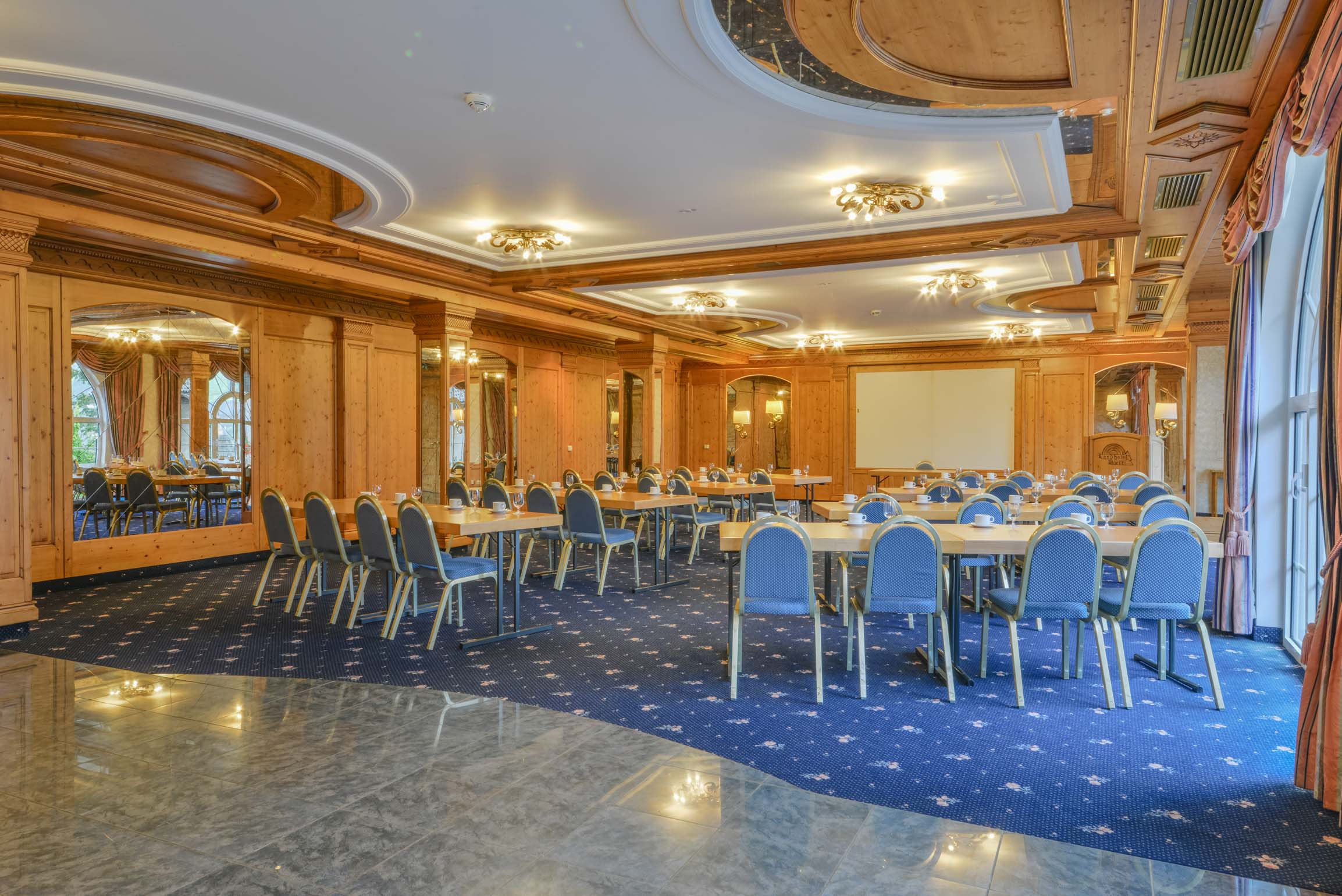 Landhotel Doerr in Bad Laasphe – Konferenzraum mit blauen Stühlen und Leinwand | Wellnesshotel Sauerland
