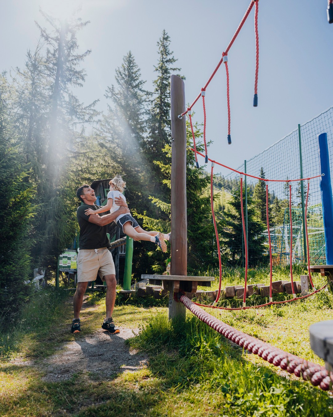 Das KATSCHBERG in Katschberghöhe – Vater spielt mit Kind auf einem Outdoor-Spielplatz | Wellnesshotel Kärnten