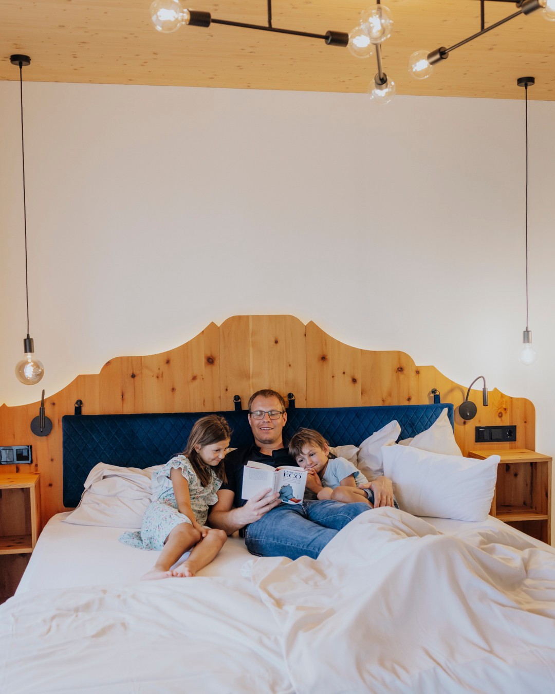 Das KATSCHBERG in Katschberghöhe – Familie liest entspannt im gemütlichen Hotelzimmer | Wellnesshotel Kärnten