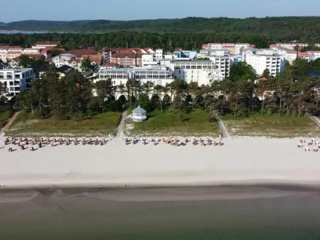 Luftaufnahme des Grand Hotel Binz in Binz, Rügen, direkt am breiten Sandstrand mit Strandkörben und Ostseeblick.
