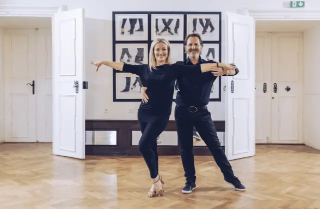 Zwei Personen in Tanzpose in einem hellen Raum mit Parkettboden und Kunst an der Wand im Sporthotel Royer Schladming.