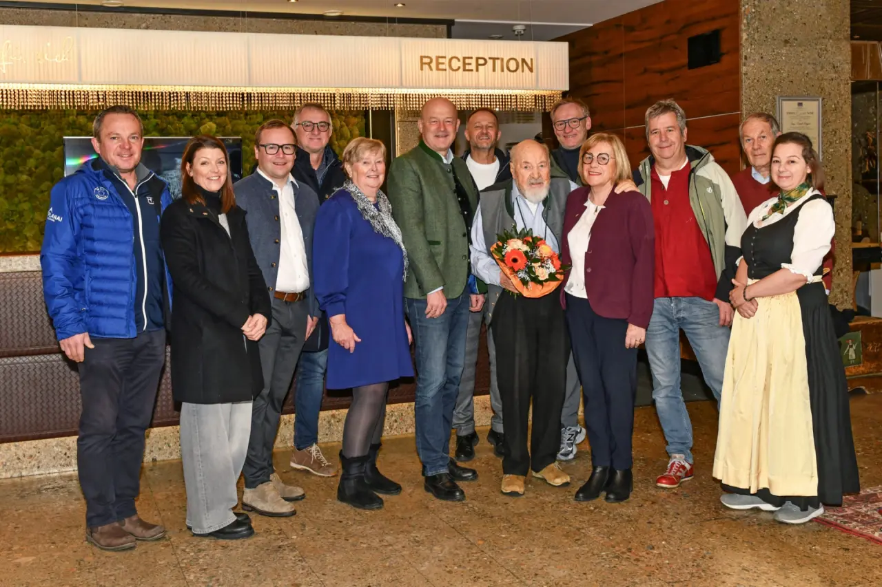 Gruppe von Gästen und Personal in der Rezeption des Sporthotel Royer Schladming mit Blumenstrauß.