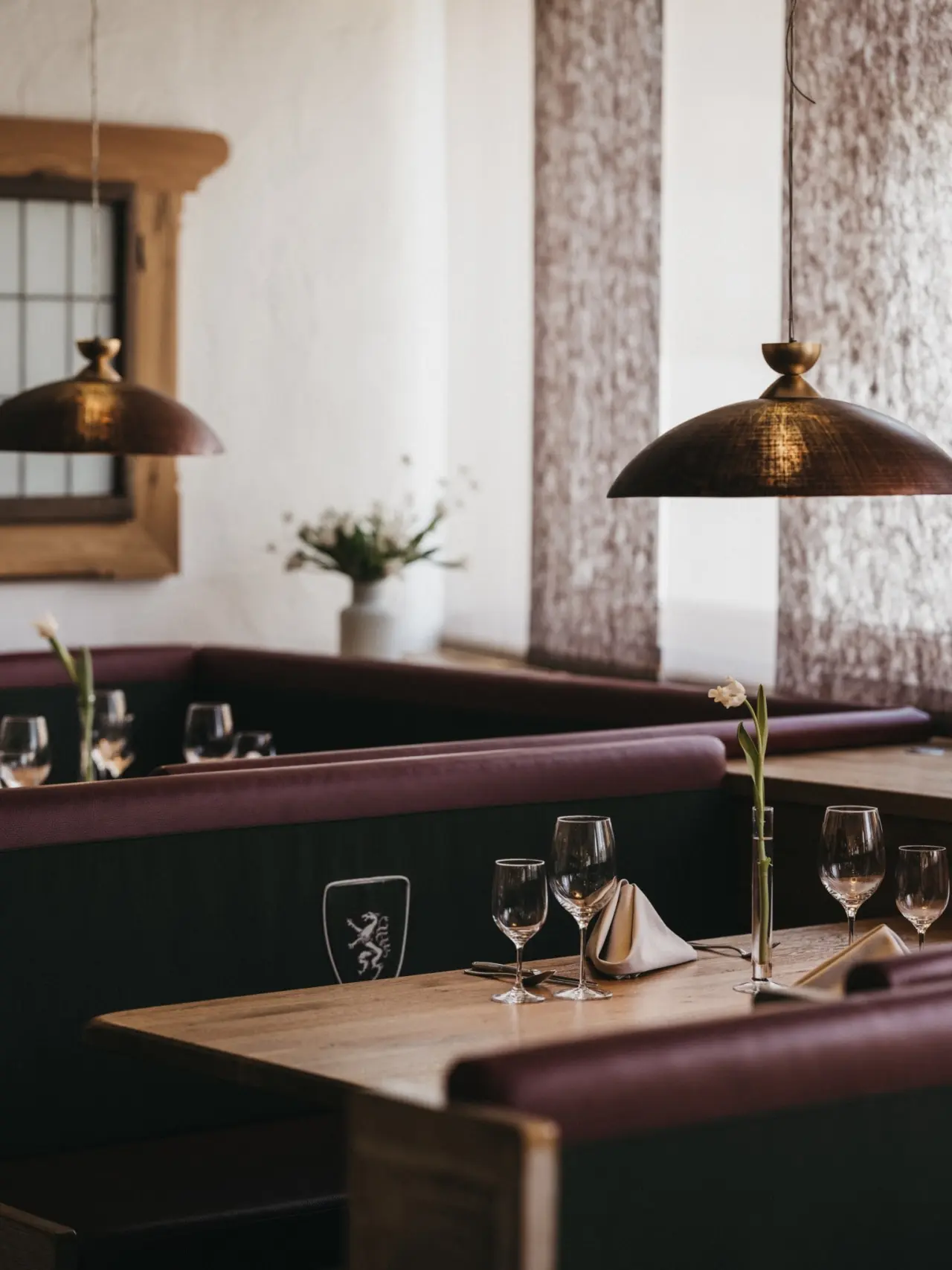 Gemütliches Restaurant mit Holztischen und gepolsterten Bänken im Sporthotel Royer Schladming, einladende Atmosphäre.