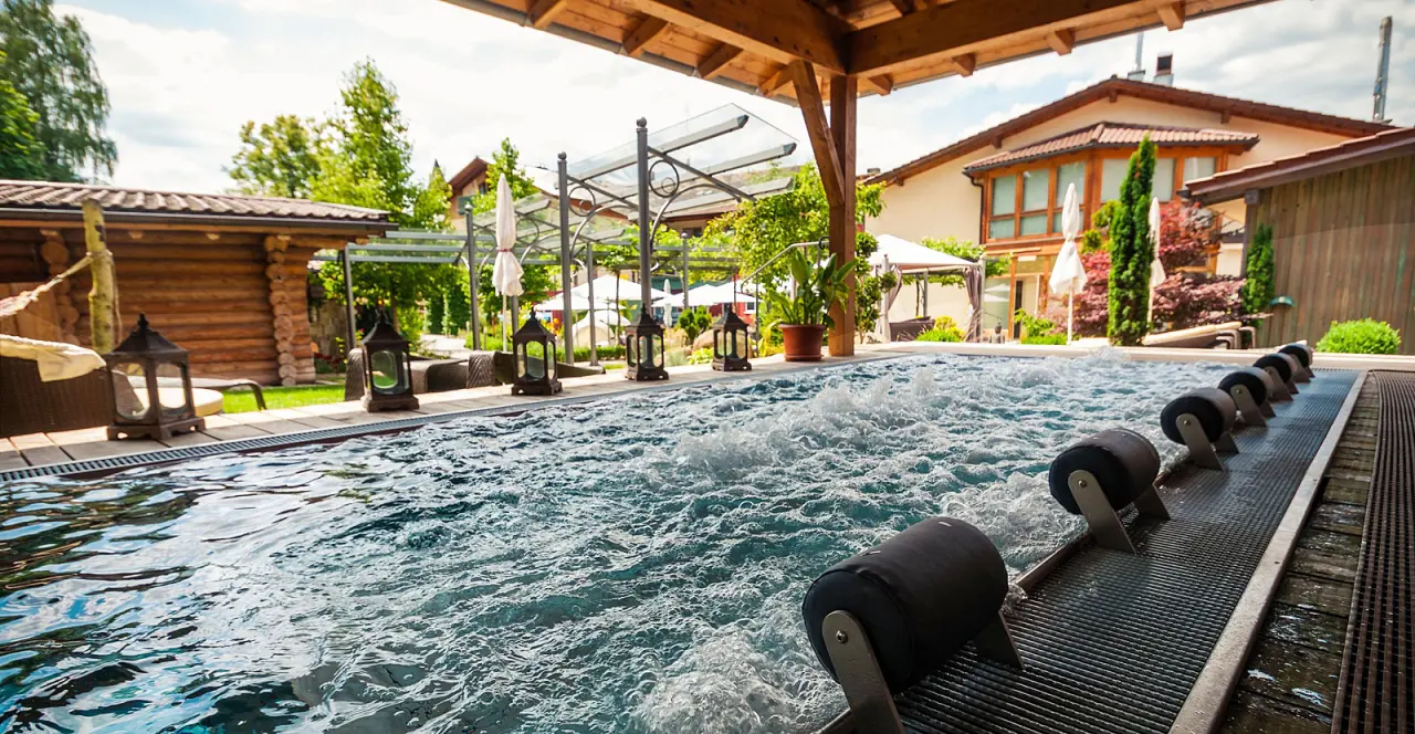 Beheizter Aussen-Whirlpool mit Sprudelfunktion und Saunahaus im Wellnessgarten des Hotel Zum Kramerwirt.