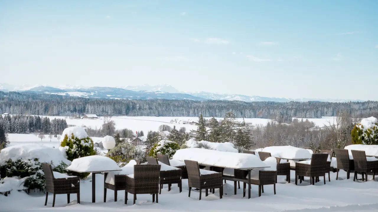Schneebedeckte Terrasse mit Alpenpanorama und Sitzgelegenheiten im Berghotel Jägerhof