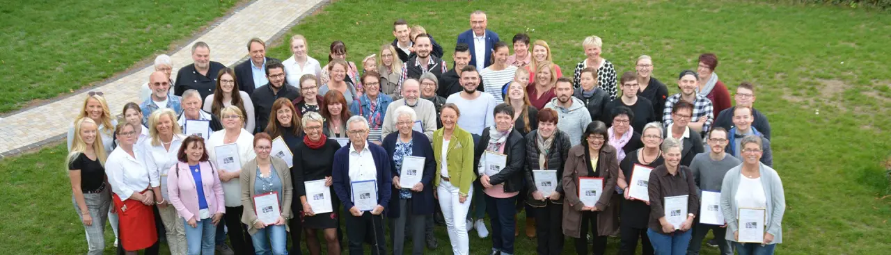 Gruppenfoto von Mitarbeitern oder Gaesten des Parkhotel Zum Stern auf einer gruenen Wiese.