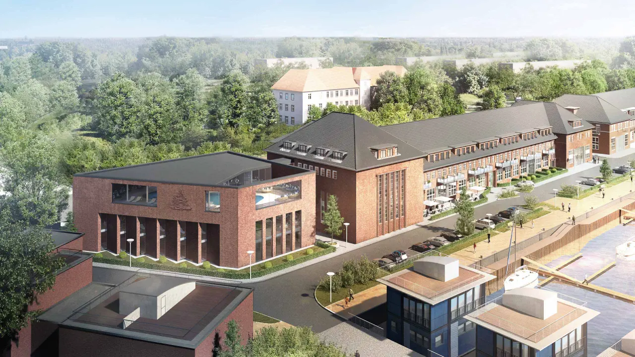 Luftaufnahme des Hotelkomplexes Das James am Hafen mit Yachten und grüner Umgebung. Der Poolbereich ist sichtbar.