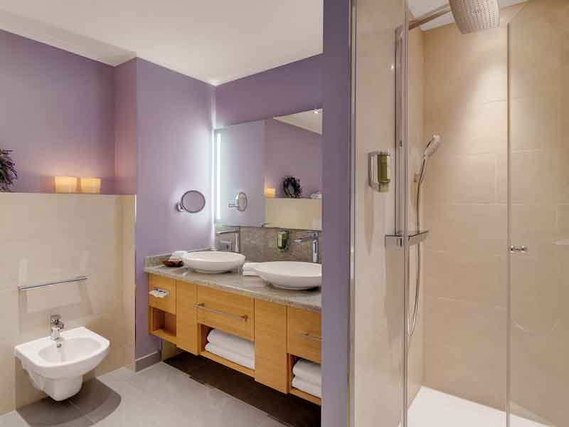 Hotel Sonnengut in Bad Birnbach – Helles Badezimmer mit zwei Waschbecken und Dusche | Wellnesshotel Rottal