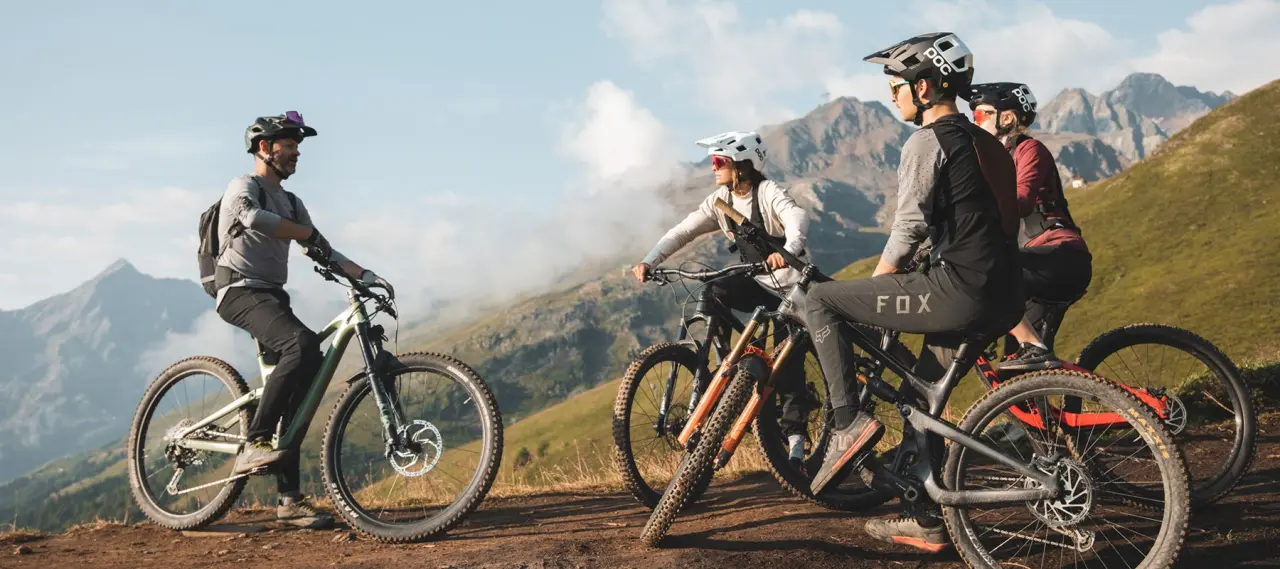 Mountainbiker-Gruppe macht Pause mit Bergblick. Outdoor-Aktivität in den Alpen nahe dem Hotel Tyrolerhof.