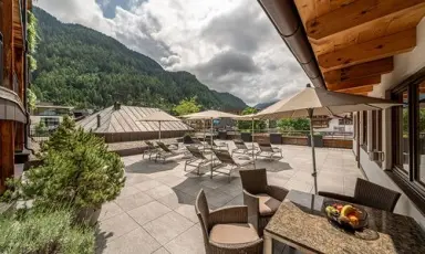 Sonnige Panoramaterrasse mit Liegestühlen und Bergblick im Hotel Tyrolerhof. Perfekt für Entspannung im Freien.
