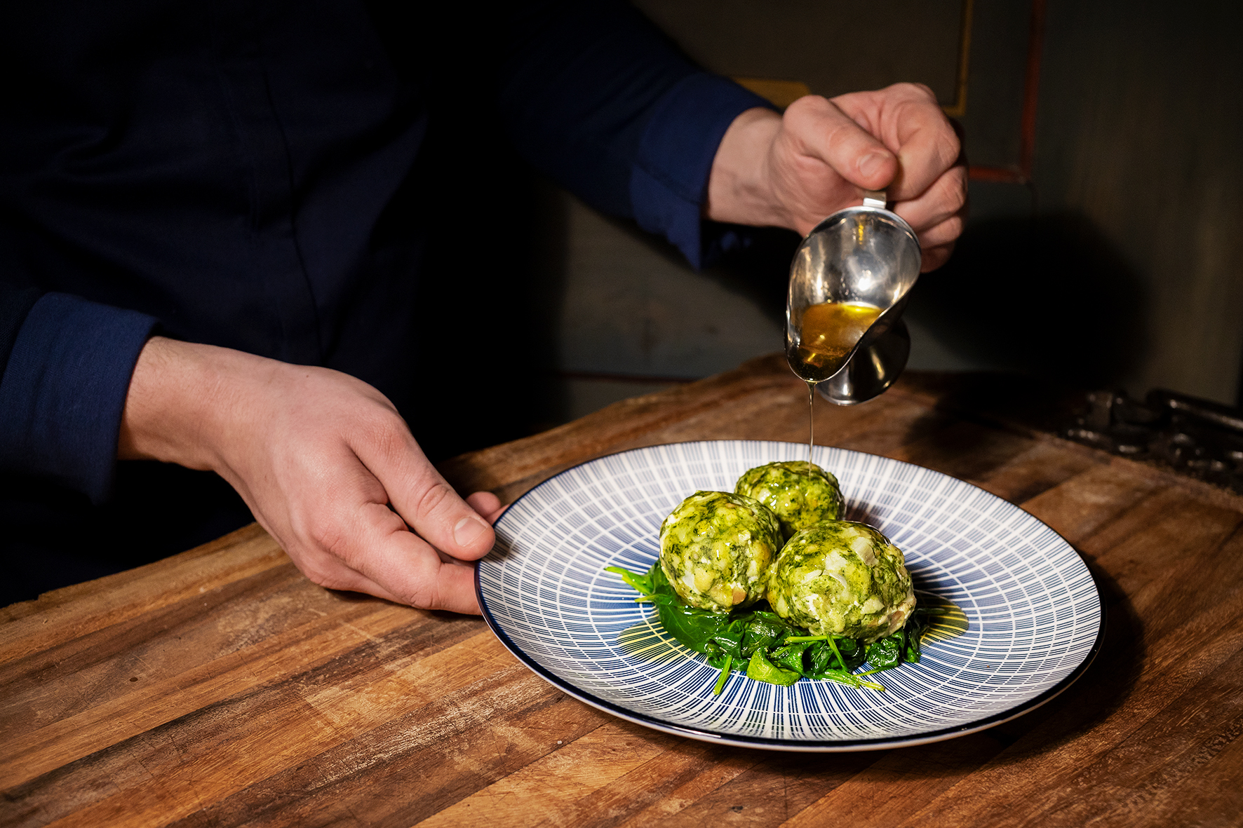 Landgasthof Karner in Frasdorf – Koch serviert frische Spinatknödel mit Soße | Wellnesshotel Chiemgau